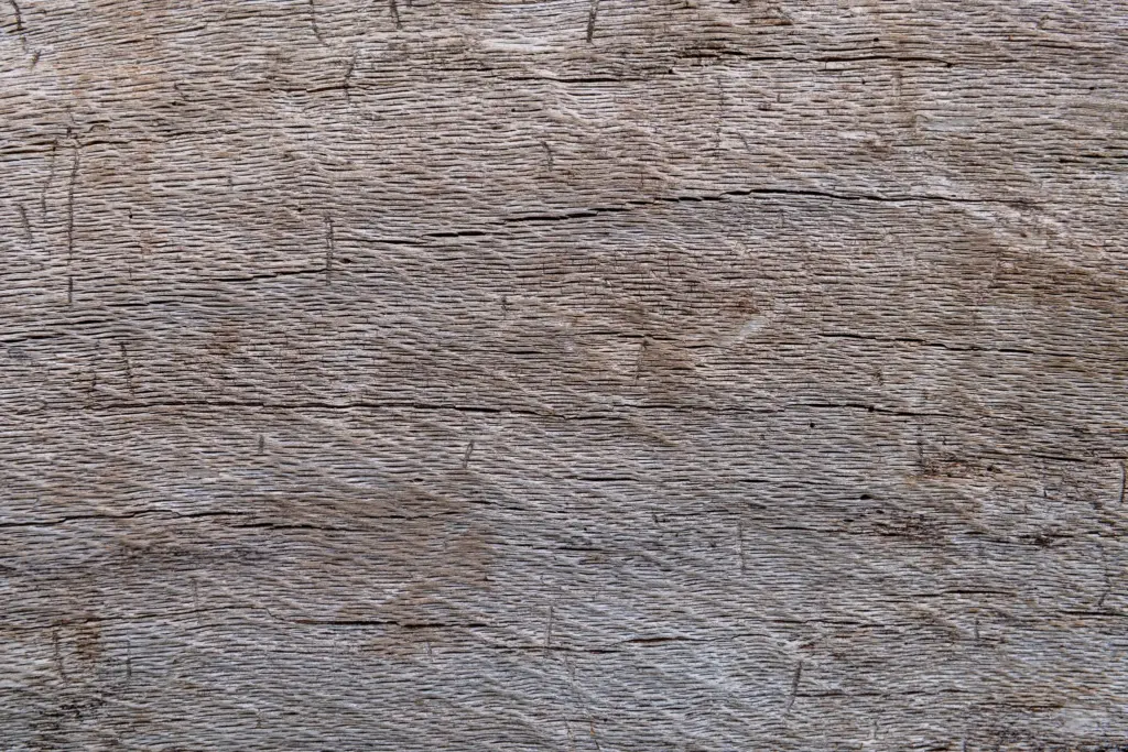 Detailed close-up of weathered wooden surface with natural grain and cracks.